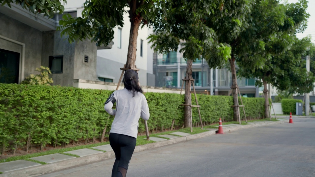 女人在街上与大自然慢跑视频素材