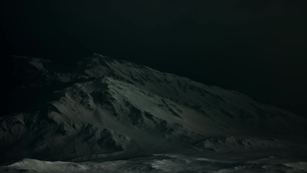 引人注目的黑色岩石山，暴风雪中夹杂着一块块的雪视频素材