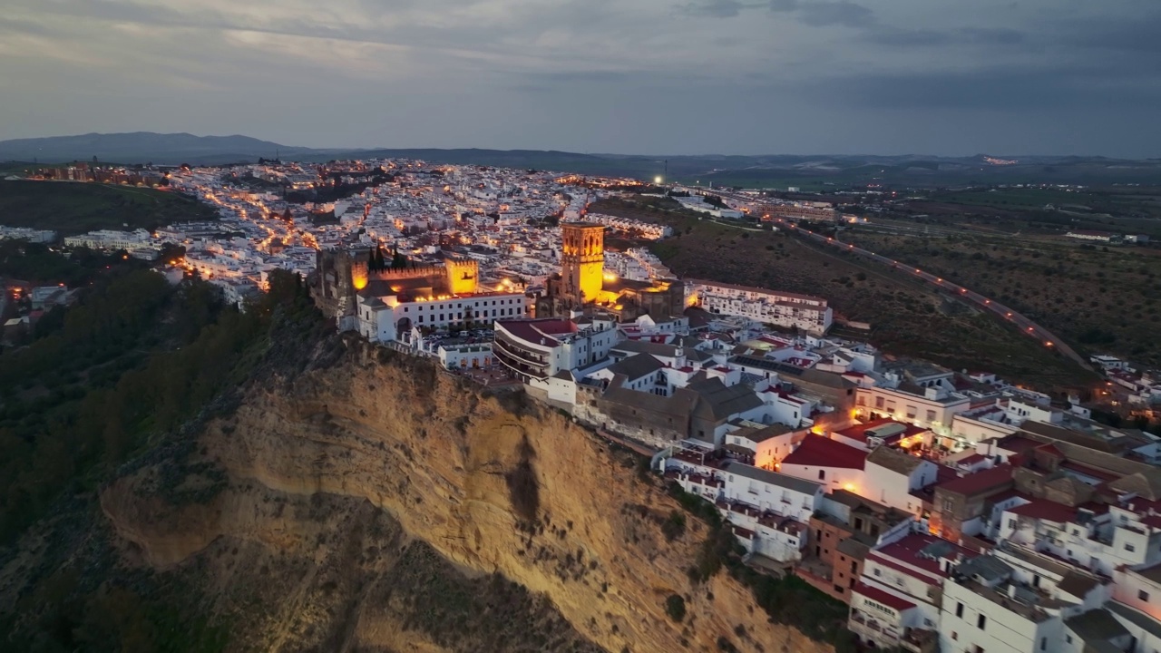 美丽的白色小镇在山上- Arcos de la Frontera -日落后的城市灯光。空中夜景Arcos de la Frontera，安达卢西亚，西班牙视频素材