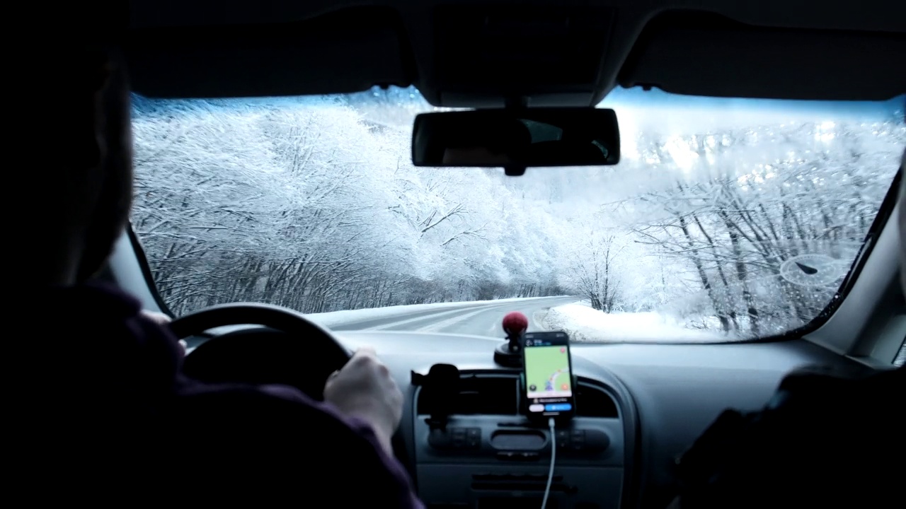 一名男子在积雪的道路上驾驶汽车视频素材