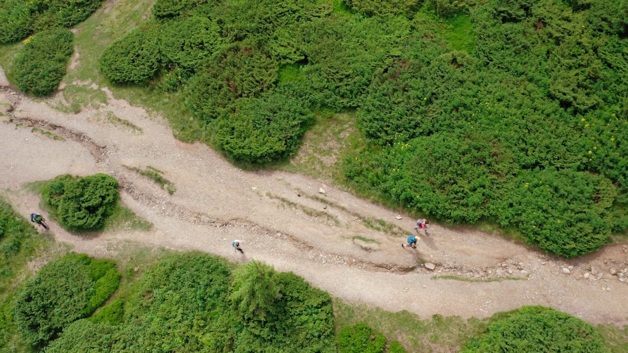 年轻人沿着山间小道走到山顶的鸟瞰图。视频素材