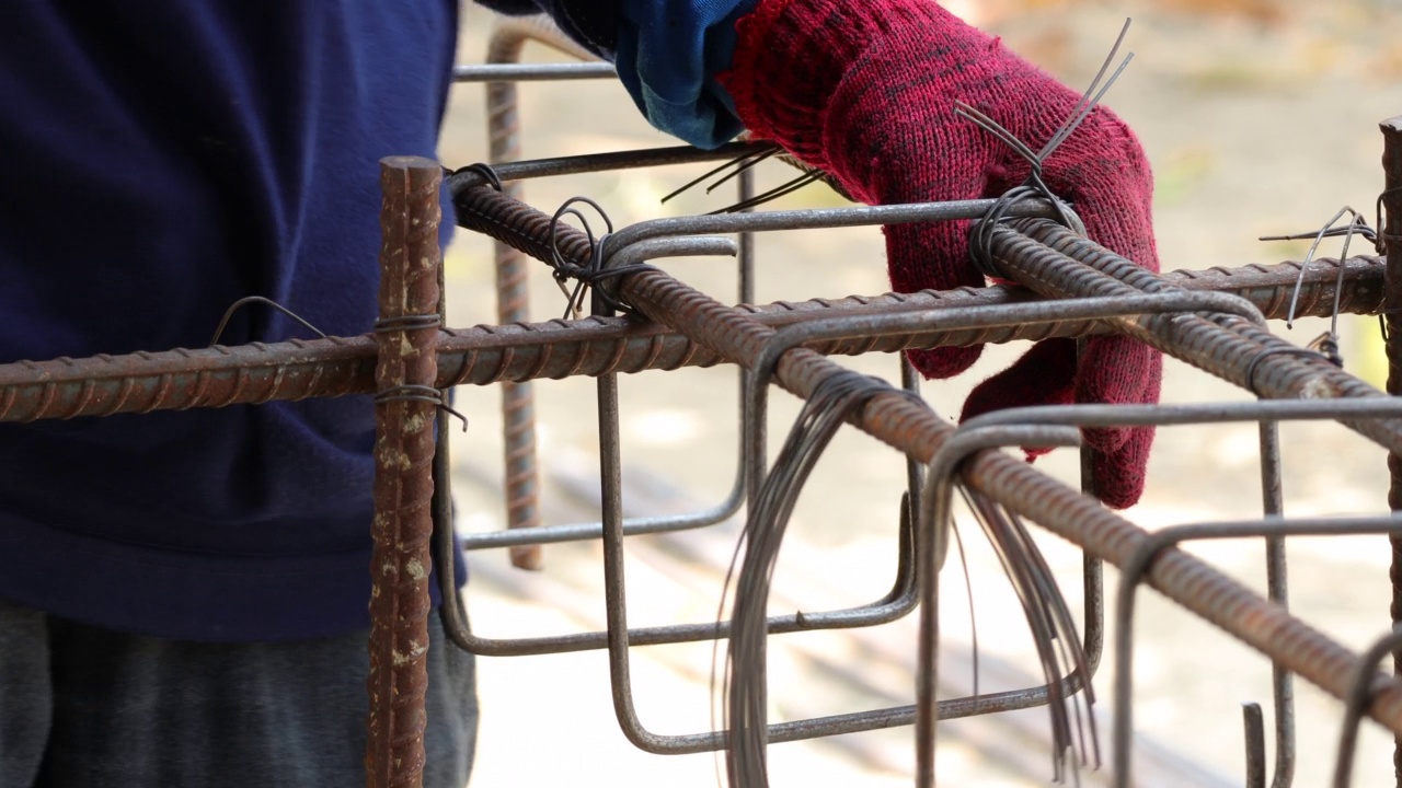 建筑工人在建筑工地制造钢筋。使用工具时，混凝土结构浇筑前需使用钢扎线。视频素材