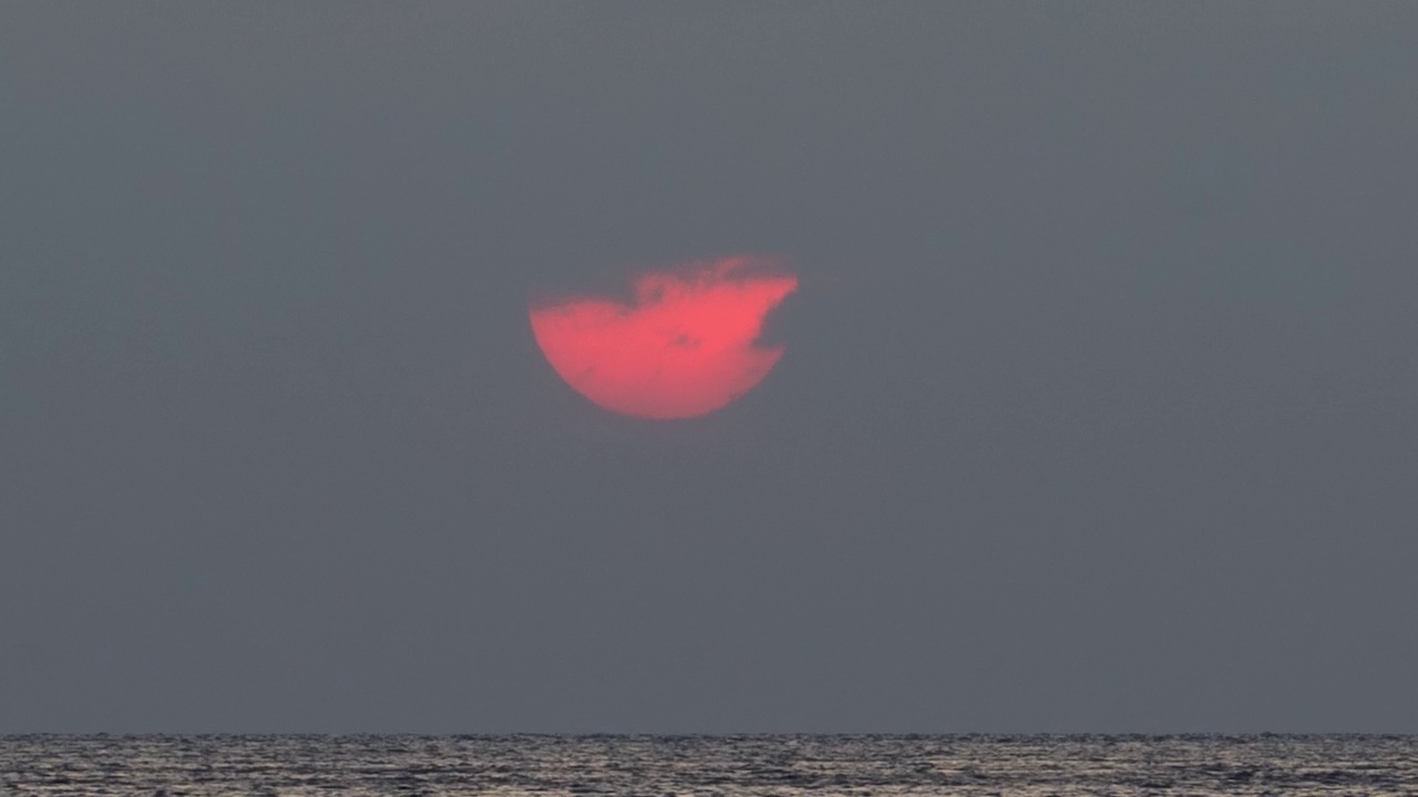 时间流逝4k，海上日落，一艘长尾船经过视频素材