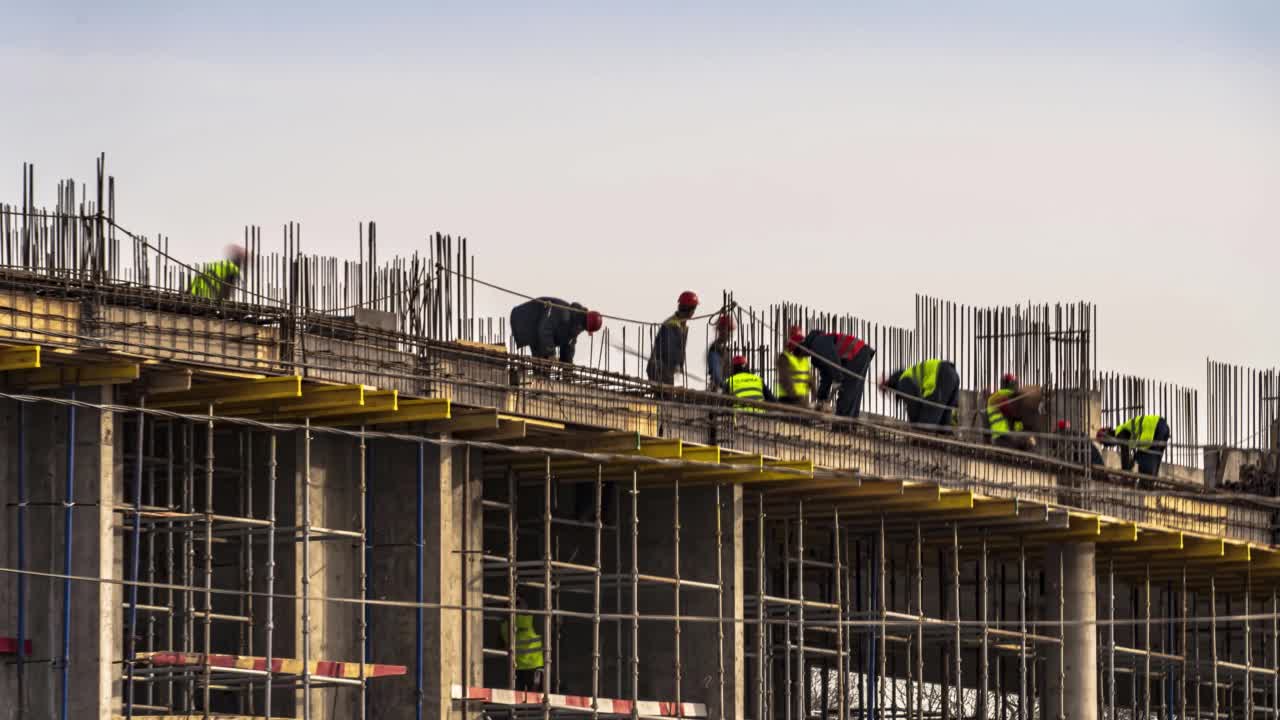 起重机和建筑工人在河堤上建设大学办公楼和学术大楼期间，精力充沛的工作，时间流逝视频下载