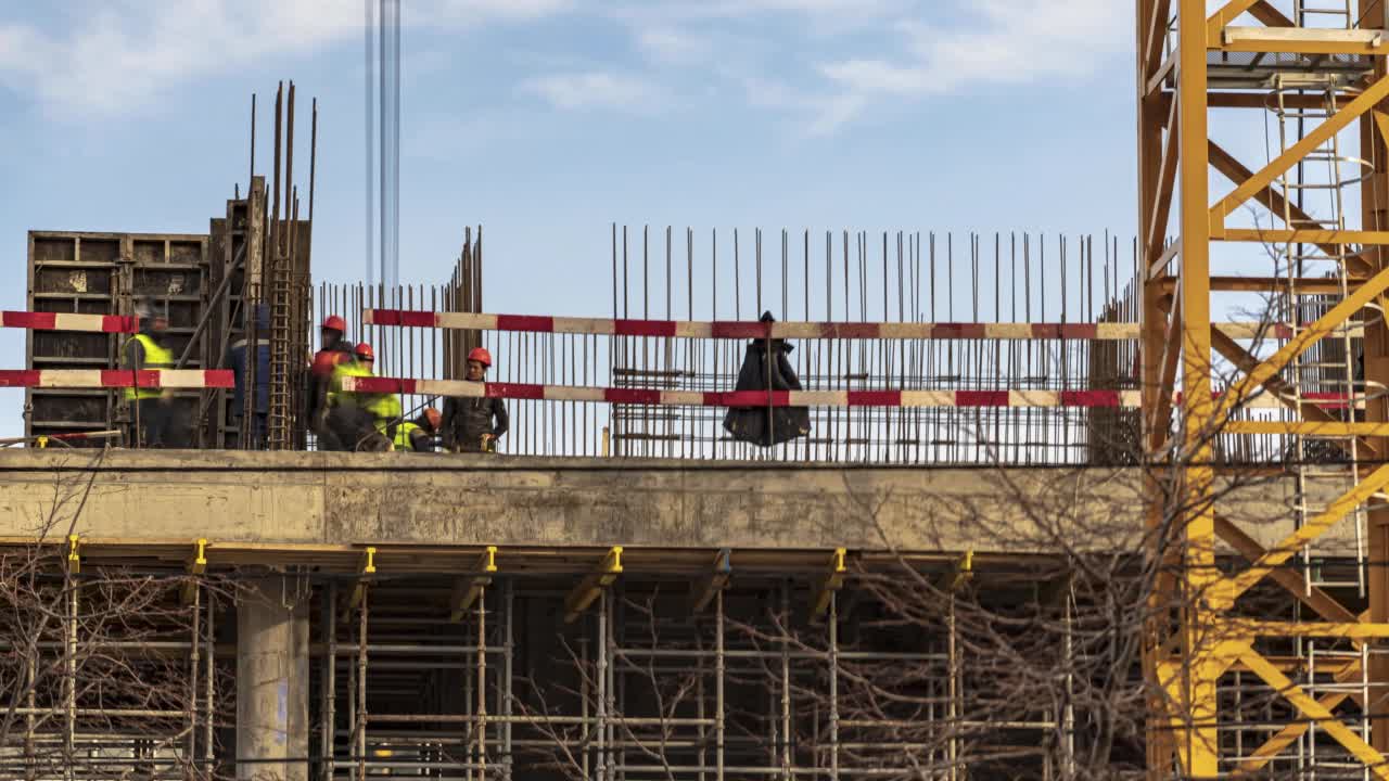 起重机和建筑工人在河堤上建设大学办公楼和学术大楼期间，精力充沛的工作，时间流逝视频素材