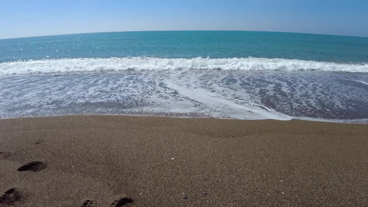 从海滩走到海边再走回来。视频素材