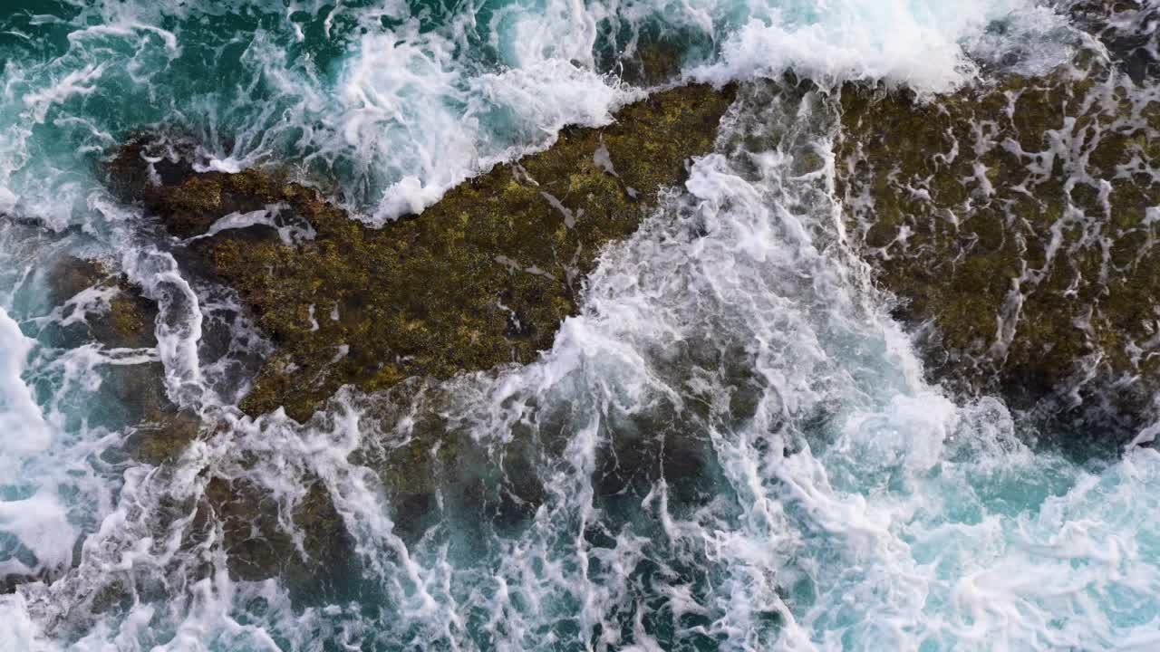 岩石，海浪和白色的泡沫。视频素材