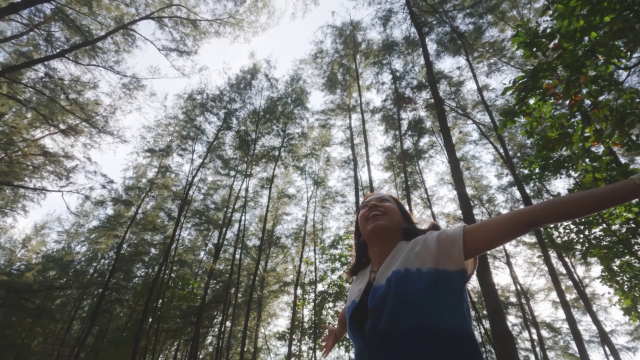 亚洲妇女旅行在松树林线的海滩上的海洋背景。视频素材