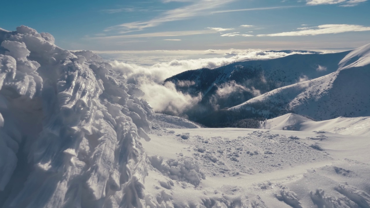 在寒冷的阳光明媚的自然中，美丽的冬季山脉在冰冻的雪堆上的神奇景色视频素材