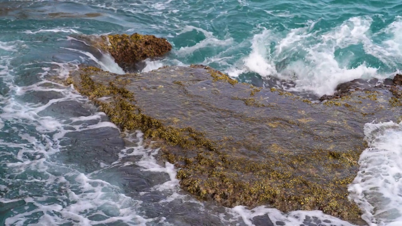 岩石，海浪和白色的泡沫。视频素材