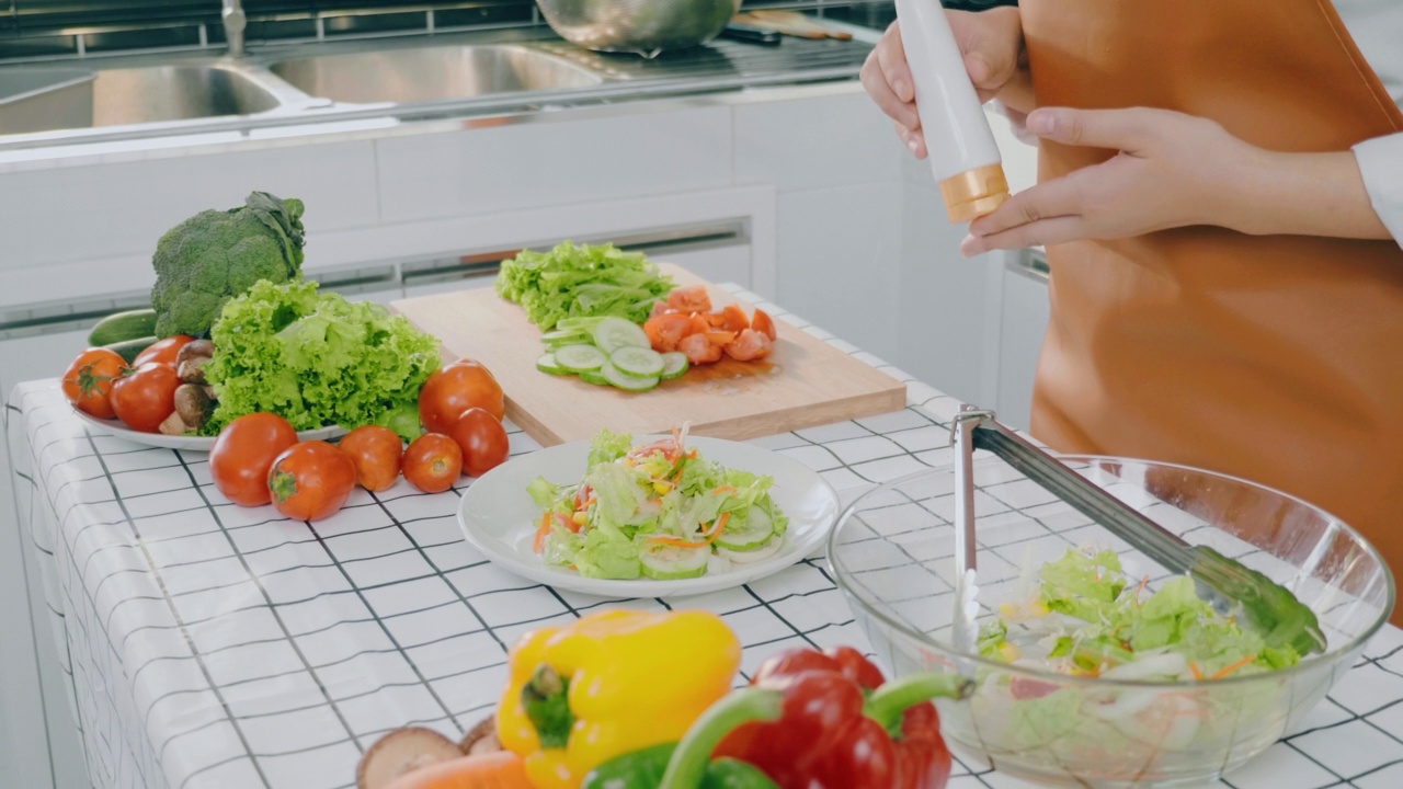 一名素食妇女在厨房做饭时用碗搅拌蔬菜沙拉视频素材