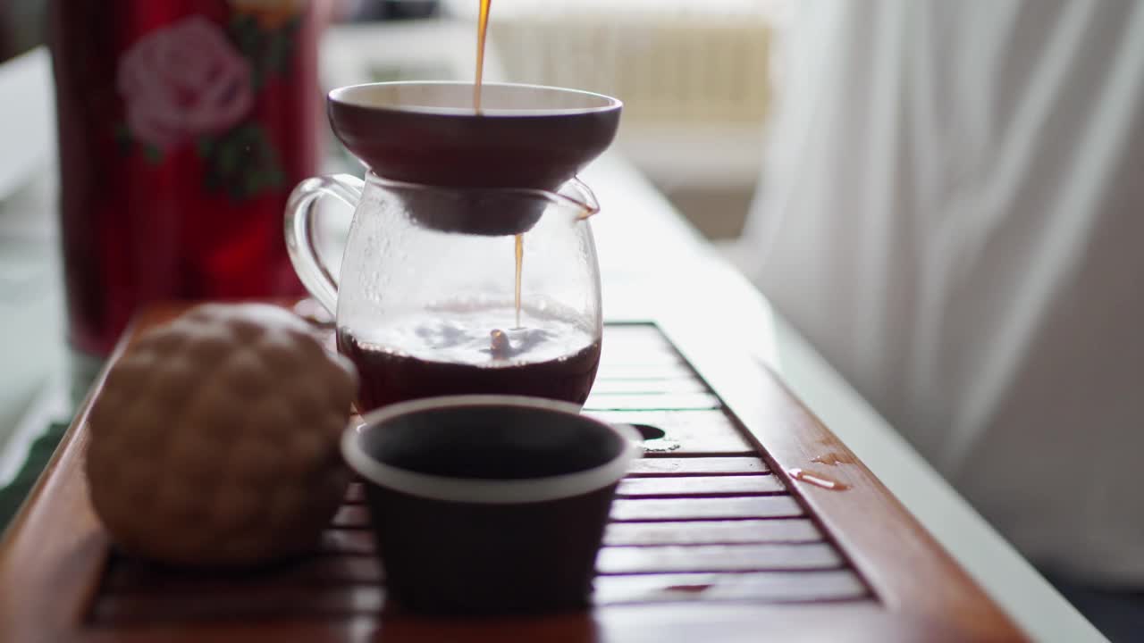 茶道用的便携桌。茶通过漏斗倒进茶壶里，使它的味道充满氧气视频素材