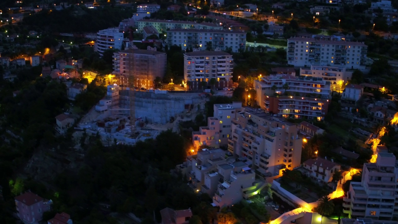 空中向前拍摄的住宅建筑在夜间照明城市-摩纳哥视频素材