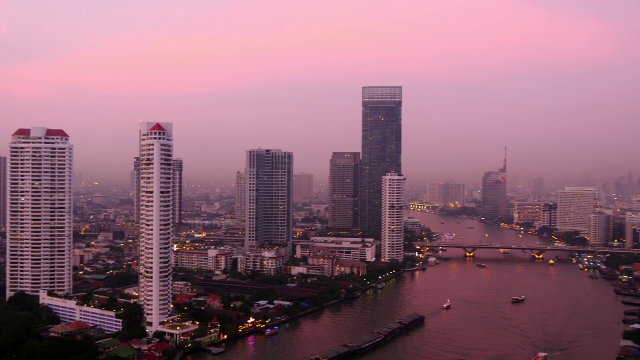 空中平移拍摄的海洋在住宅建筑在城市对天空在日落期间曼谷，泰国视频素材