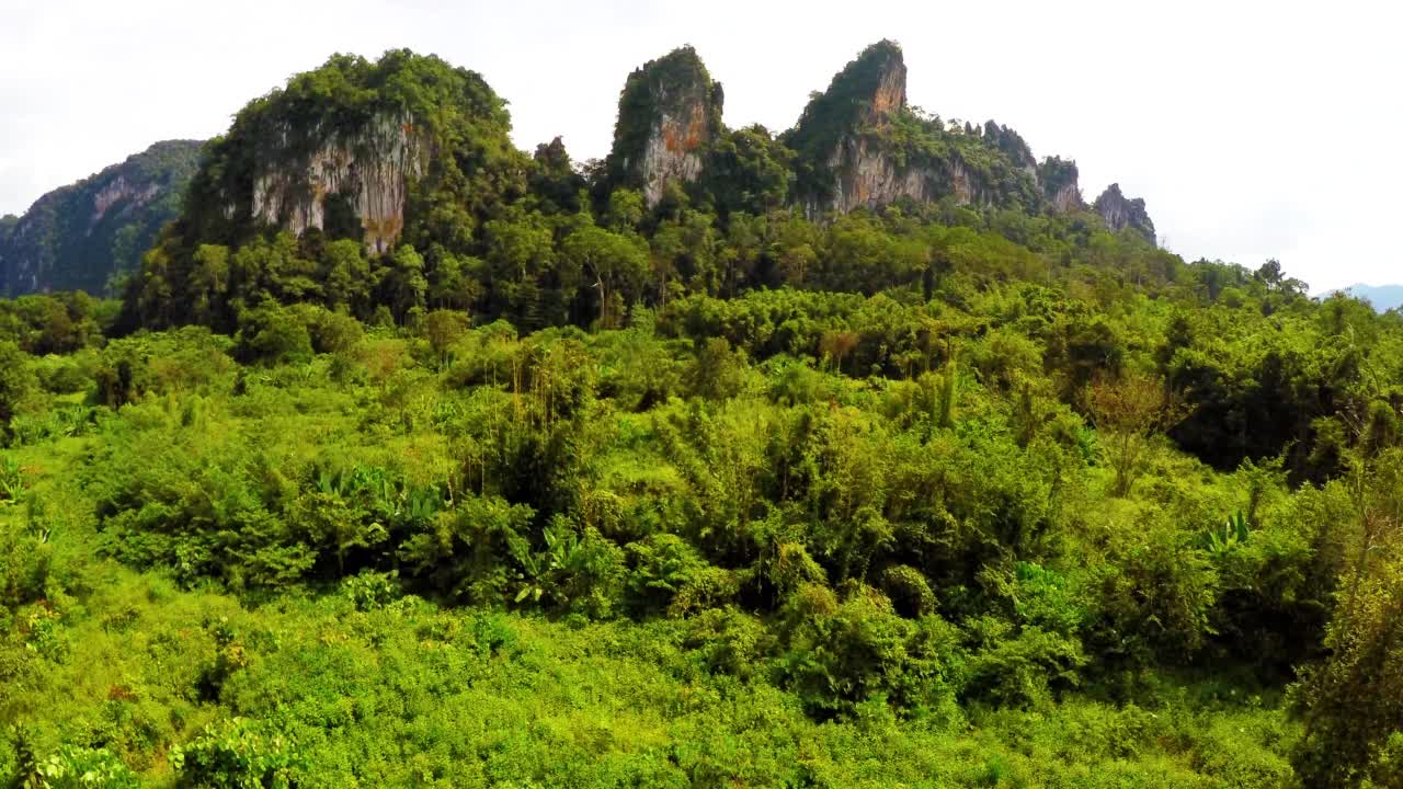 空中向前宁静的绿色山脉对晴朗的天空美丽的拍摄-曼谷，泰国视频素材