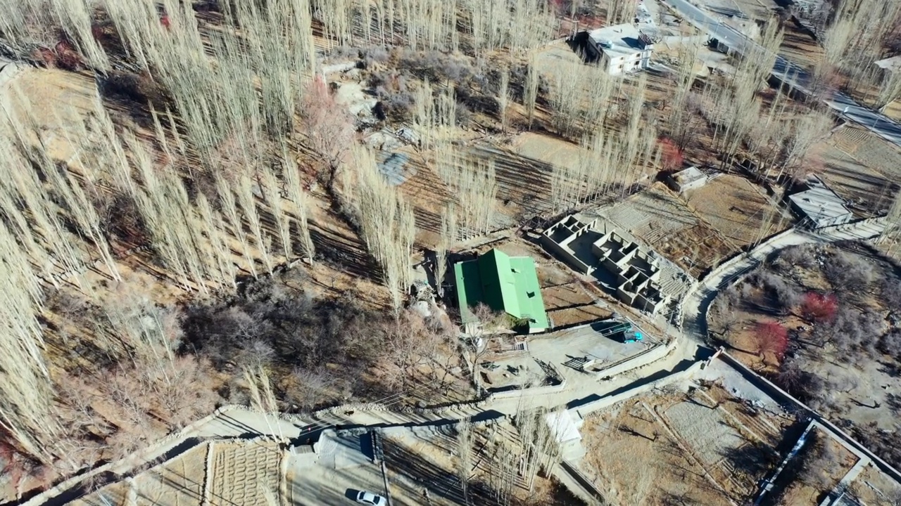 空中平移沿河岸的建筑在一个遥远的河谷-罕萨河谷，巴基斯坦视频素材