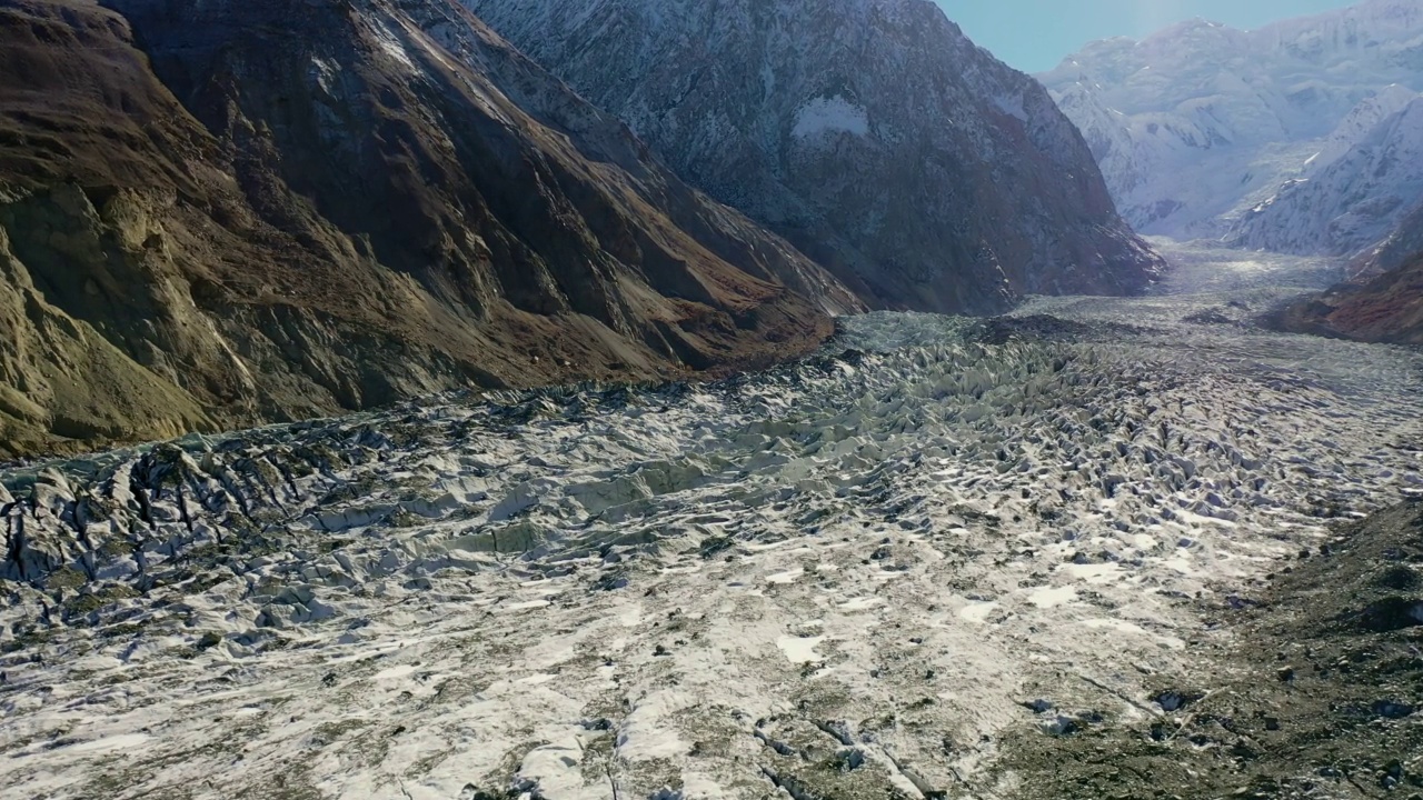 在被陡峭的雪山包围的宽阔冰川上的空中前进-巴基斯坦罕萨山谷视频素材