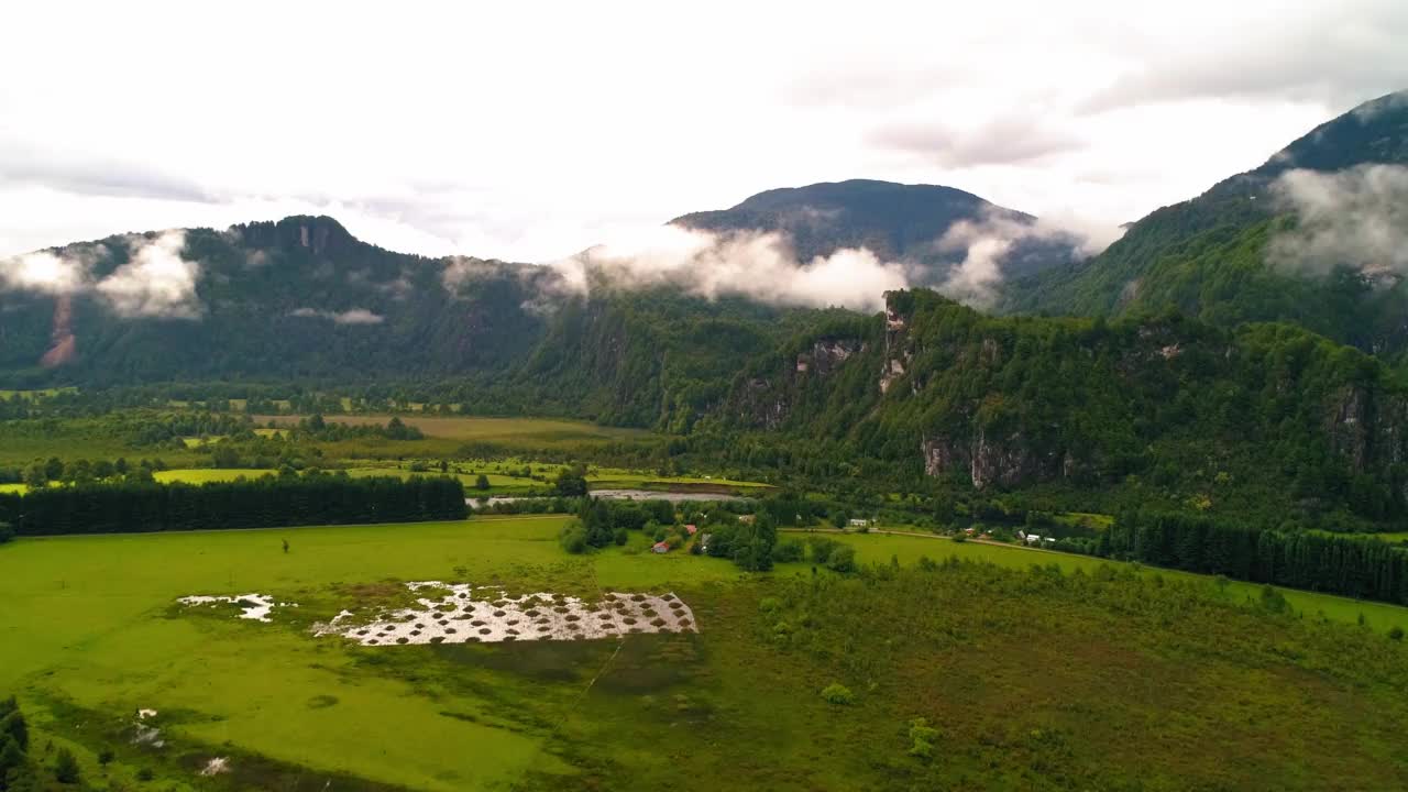 在天然山脉上的空中美丽的云，完成向后飞行在绿色景观-波多黎各查卡布科，智利视频素材