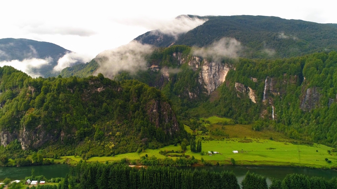 岩石上瀑布的空中美景，无人机在绿色景观中的河流上向后飞行-智利的察卡布科港视频素材