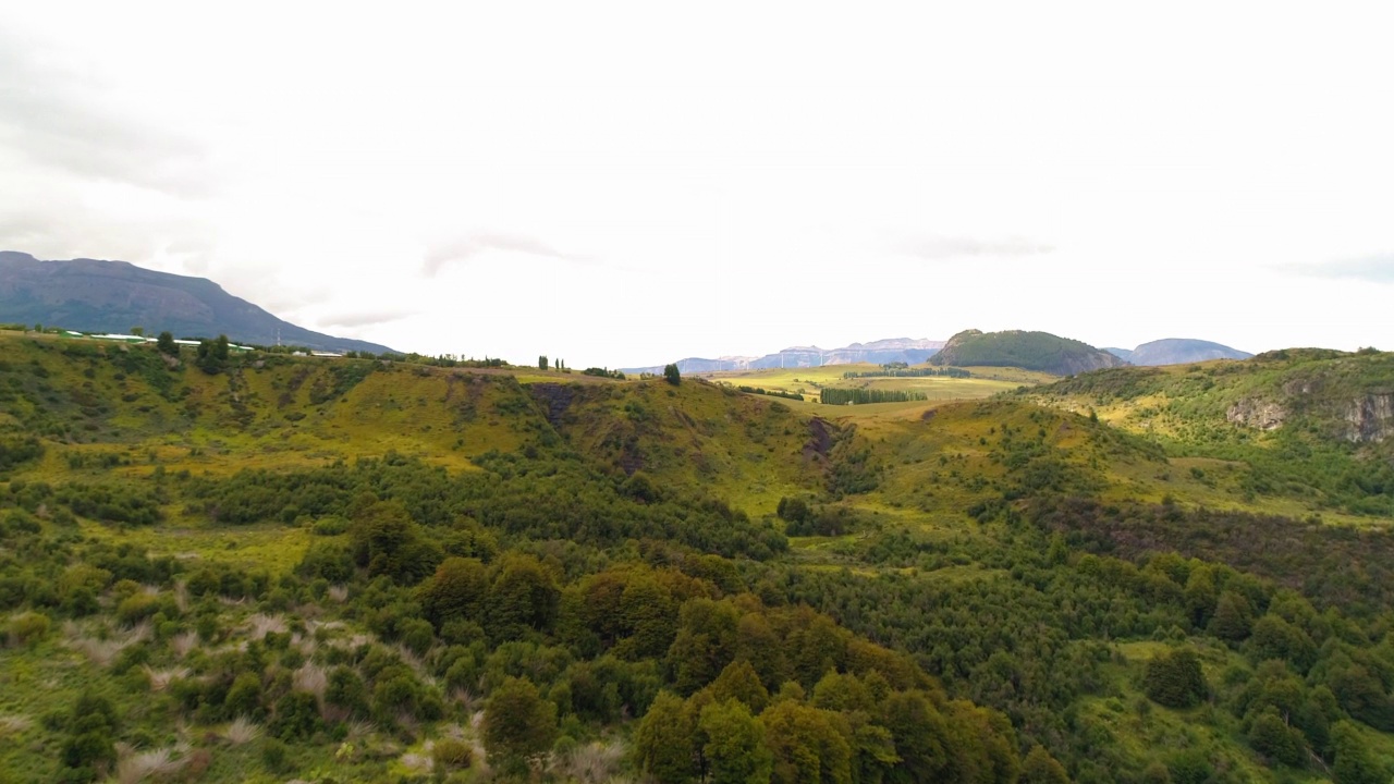 绿色山脉对天空的空中风景，无人机在河上向前飞行-查卡布科港，智利视频素材