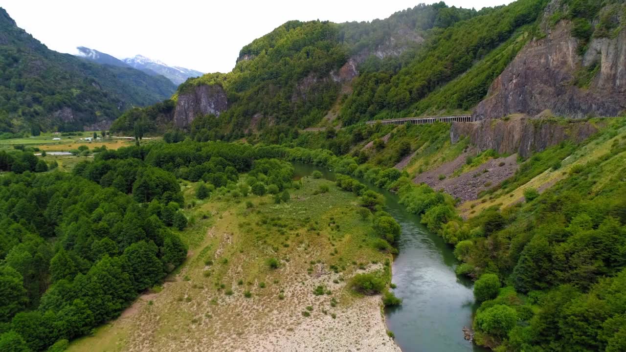 空中:河流在山脉中流动的美丽景色，无人机向前飞行在绿色景观-波多黎各查卡布科，智利视频素材