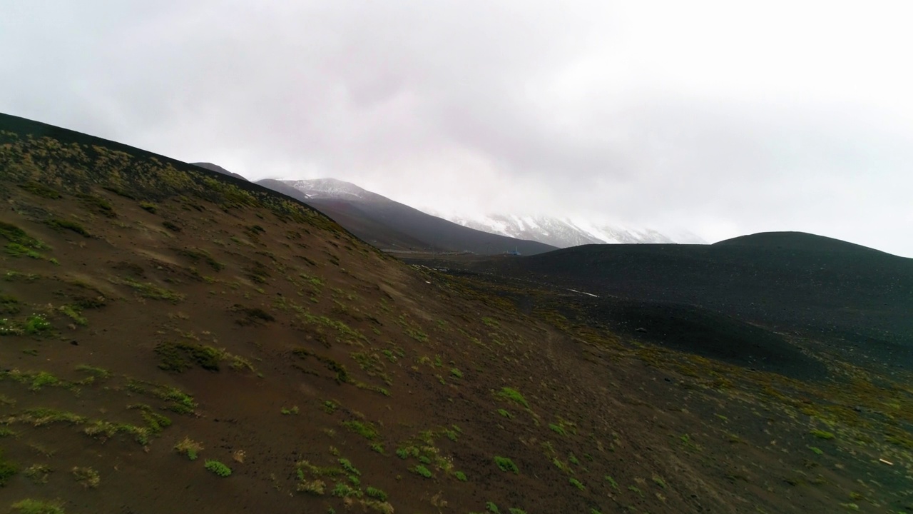 空中:多云天空下的雪山，无人机向前飞行在绿色景观-波多黎各蒙特，智利视频素材