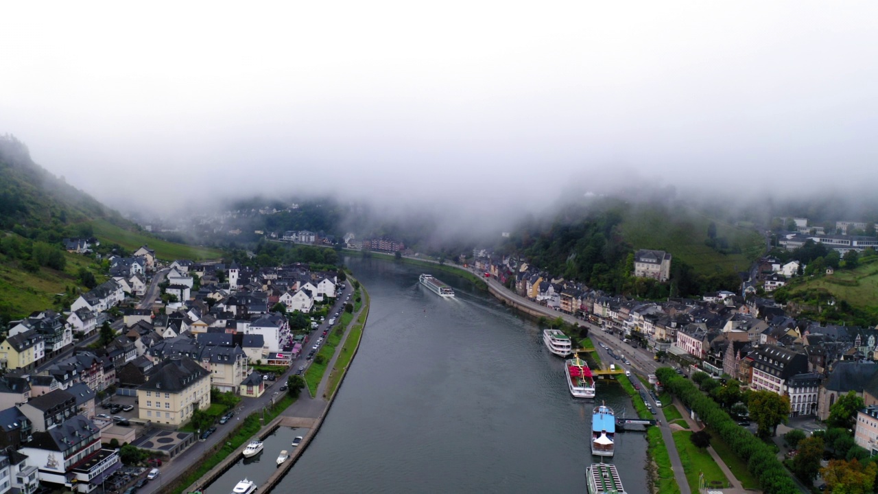 空中拍摄的雾天在小镇上的山丘，无人机飞向下在河- Cochem，德国视频素材