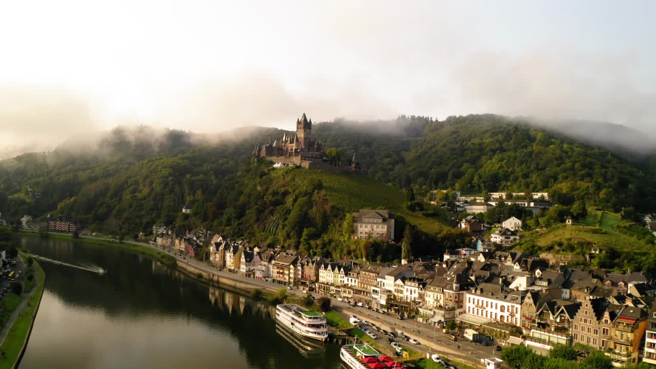 空中拍摄的11世纪山顶城堡在多云的天空，无人机飞向下在河在城镇- Cochem，德国视频素材