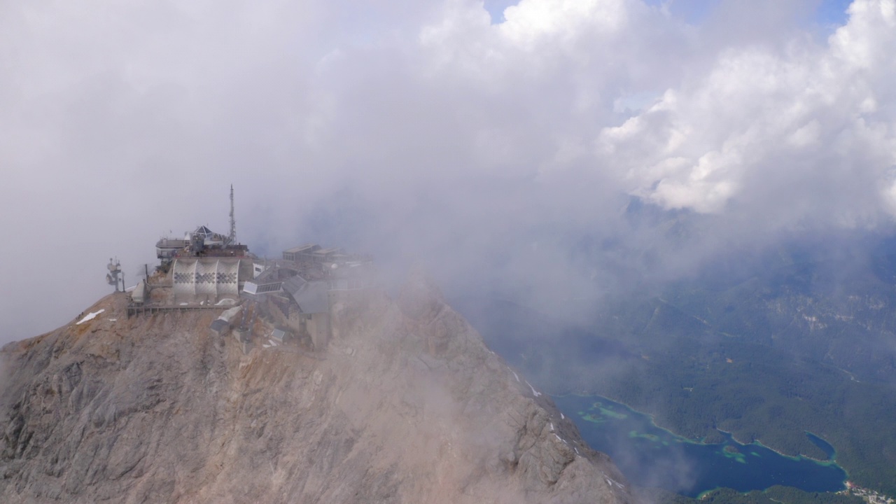 空中拍摄的山顶缆车站在湖，无人机飞行在云在冬季- Garmisch-Partenkirchen，德国视频素材