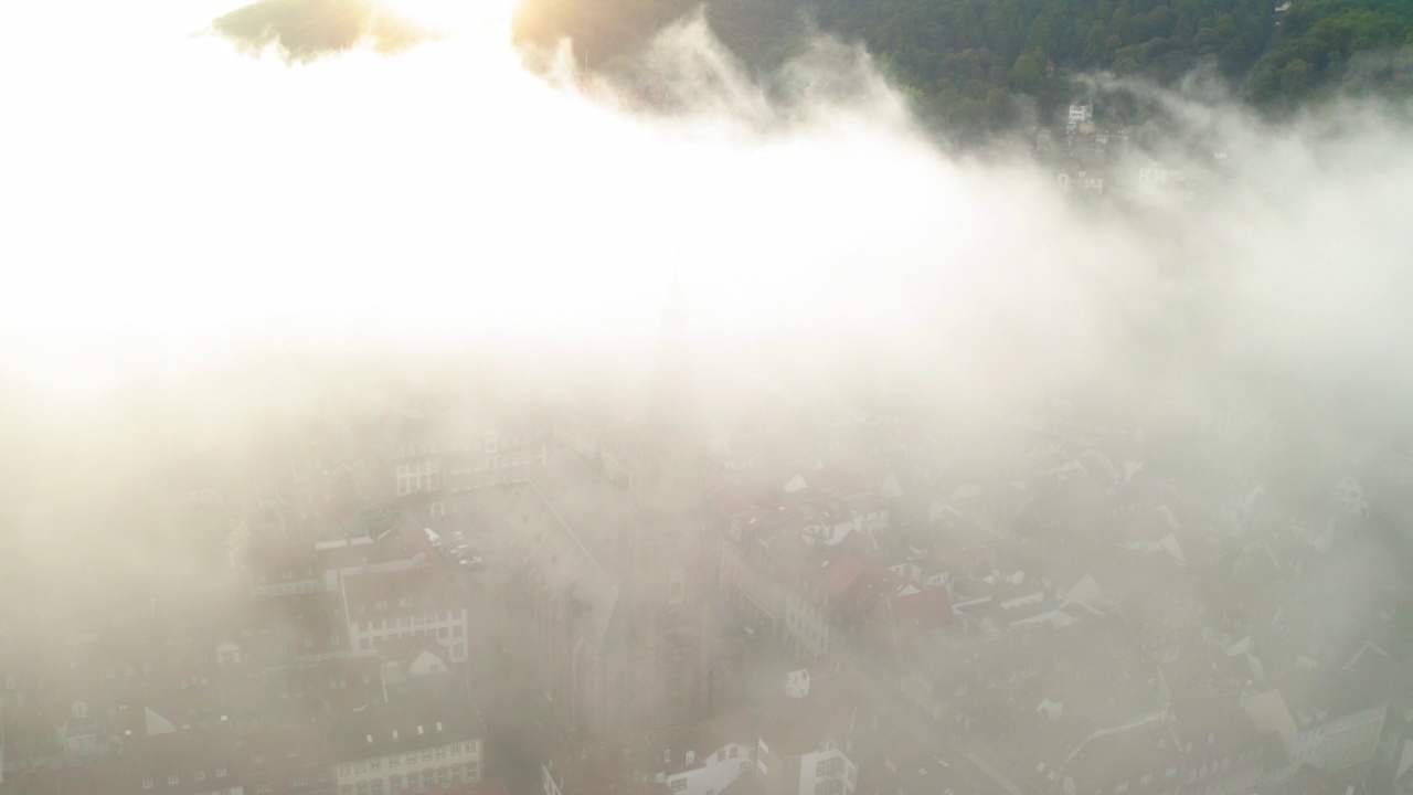 教堂在房屋中的空中美景，日出期间无人机在云中向前飞行-海德堡，德国视频素材