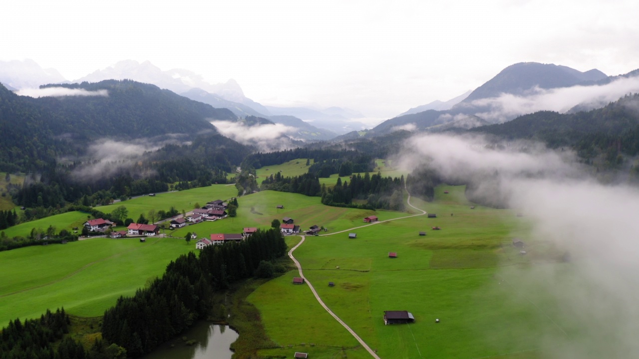 空中拍摄的山中城镇的Geroldsee湖，无人机在雾天飞行向前- Schwangau，德国视频素材