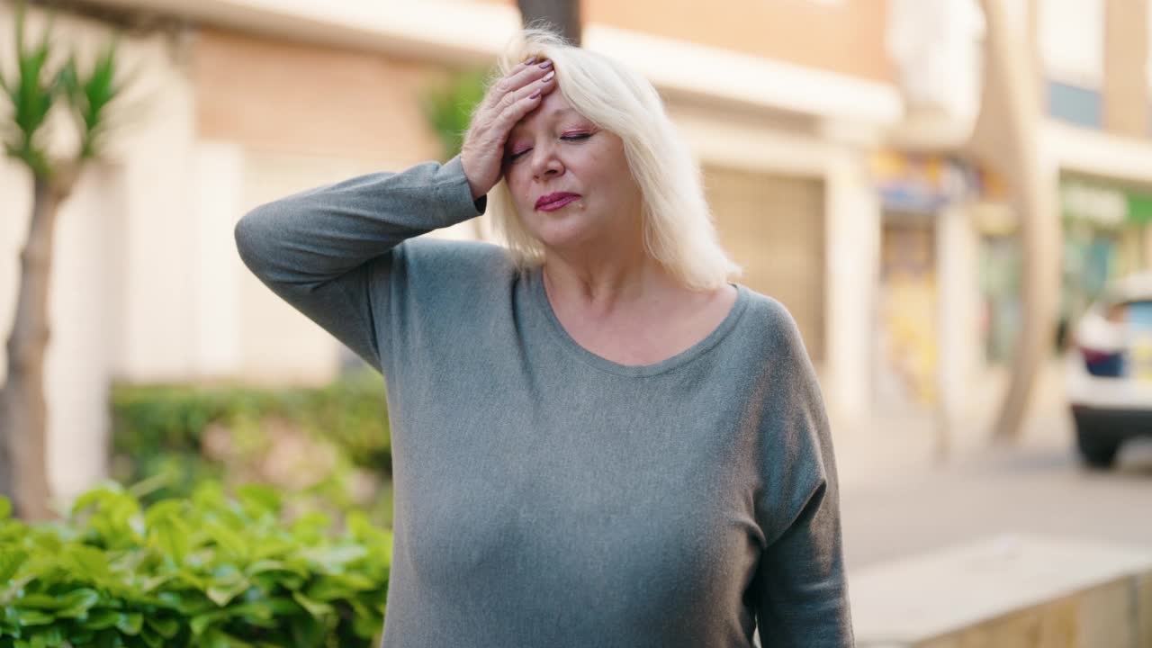 中年金发女人在街上咳嗽视频素材