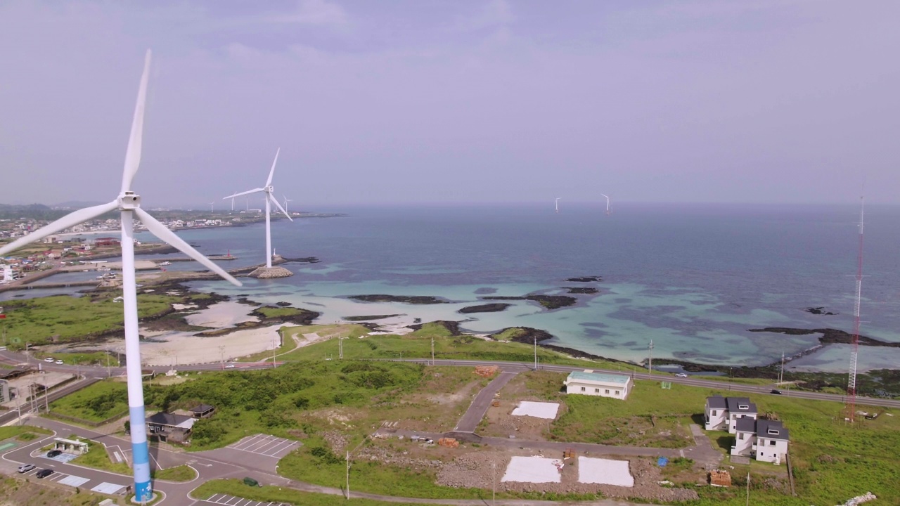 韩国济州岛金宁海岸公路附近的风力发电机涡轮视频素材