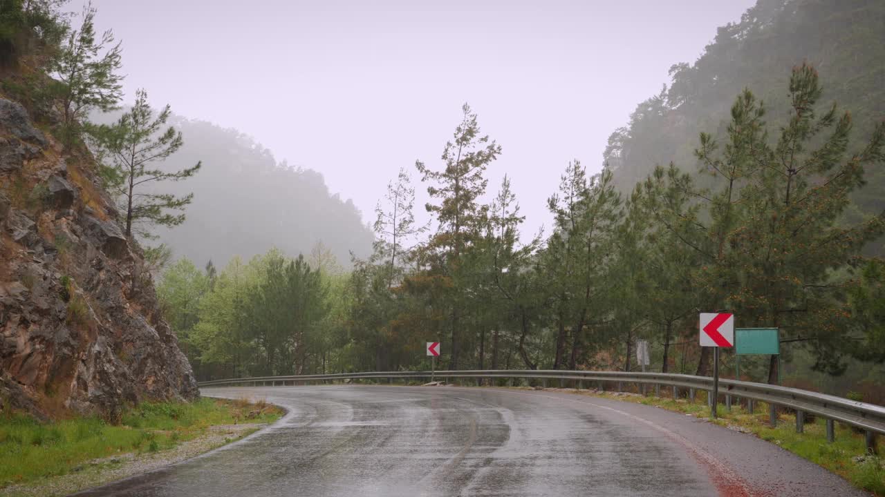 下雨天空荡荡的山路。山峰绿树林雨。神奇的山景自然视频素材