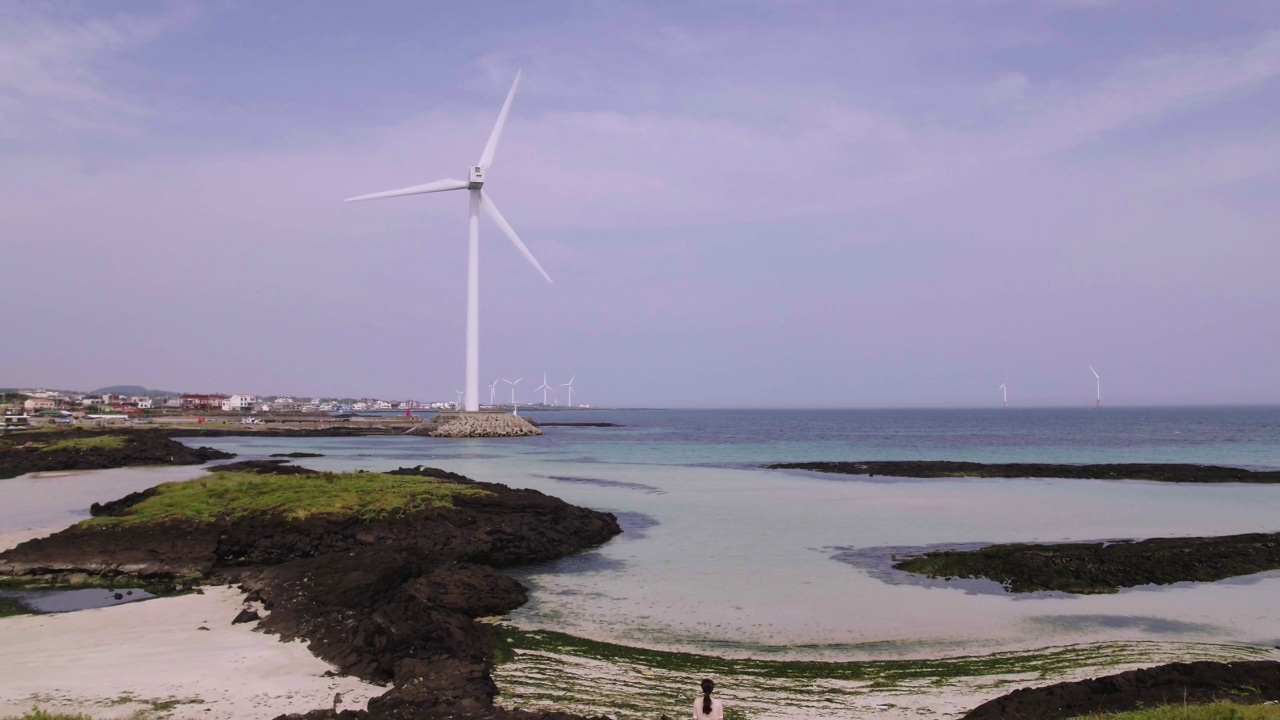 韩国济州岛金宁海岸公路附近的风力发电机涡轮视频素材