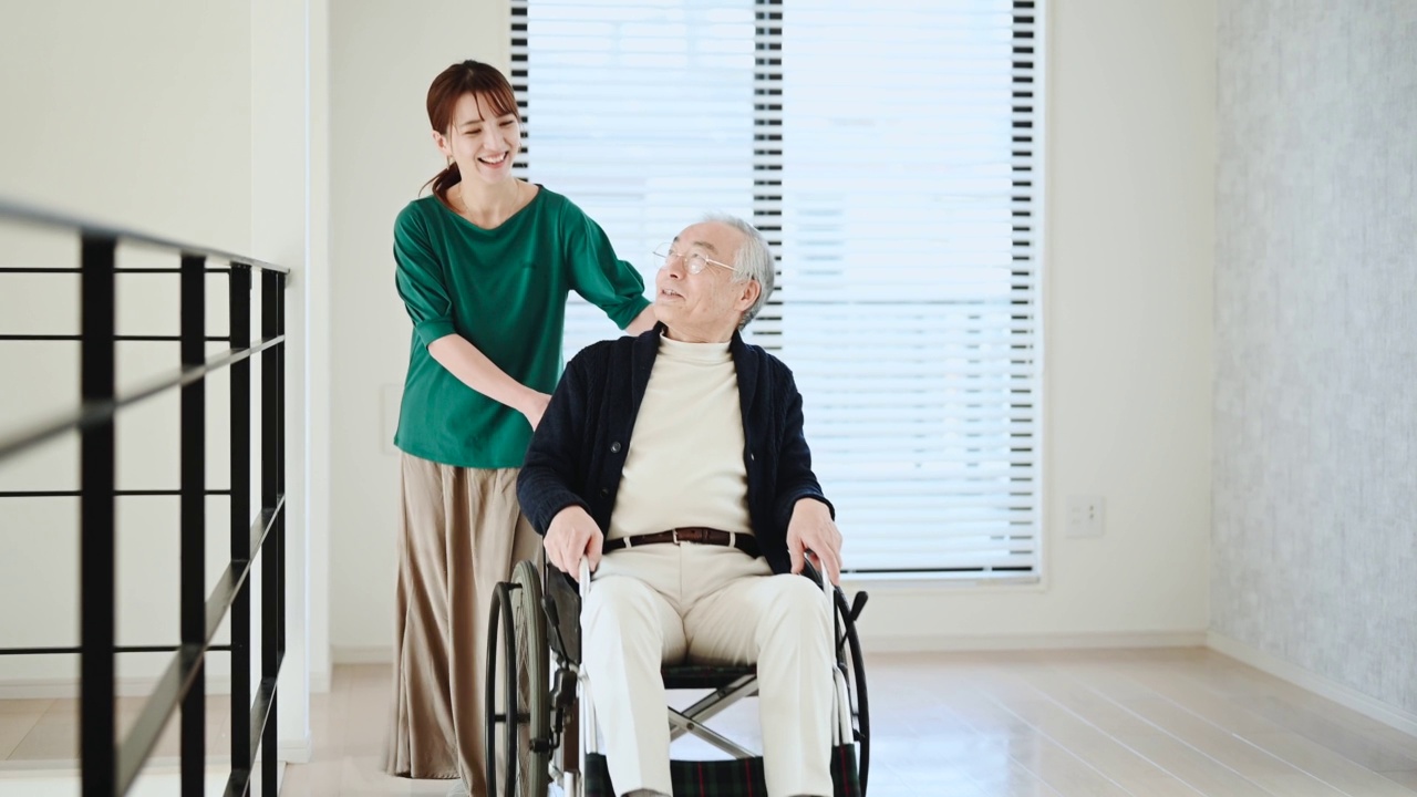 在养老院，年轻女子推着轮椅上的残疾老年男子。视频素材