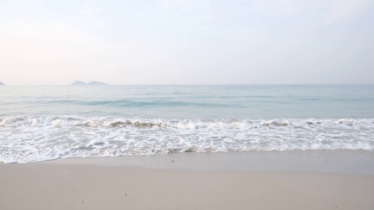 蔚蓝的天空下，海浪拍打着海滩视频素材