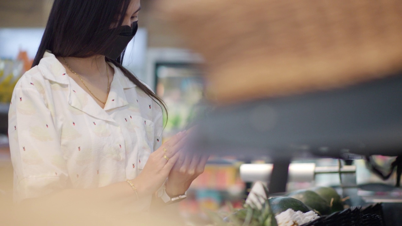 年轻的亚洲女性在杂货店购买新鲜的水果和蔬菜或消费品视频素材