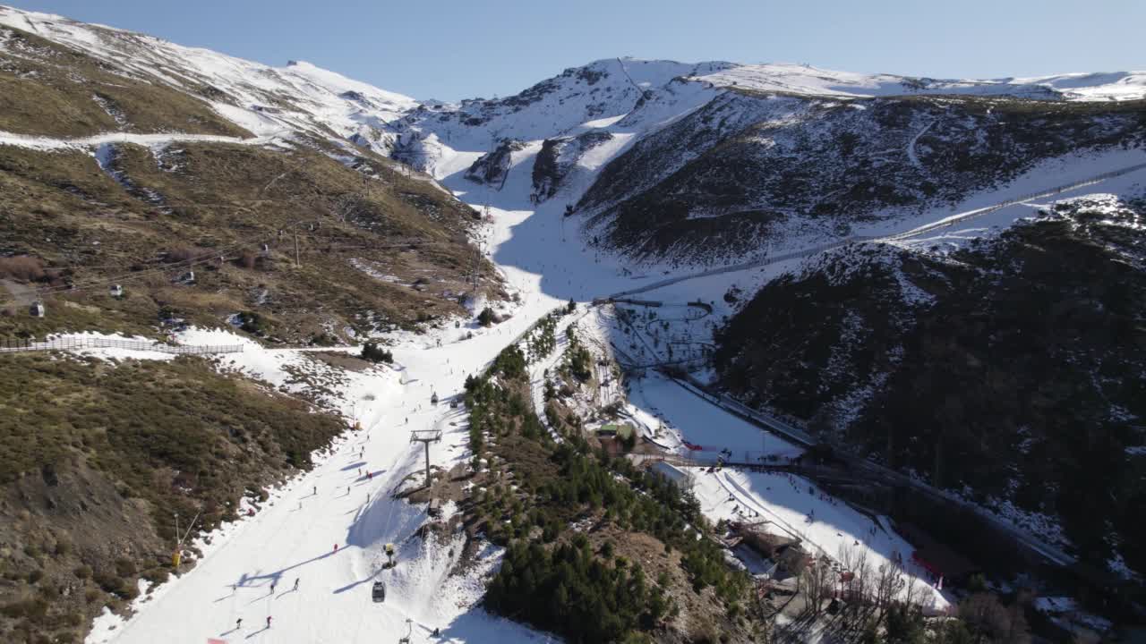 滑雪者在斜坡和索道上，内华达山脉在西班牙。空中盘旋视频素材