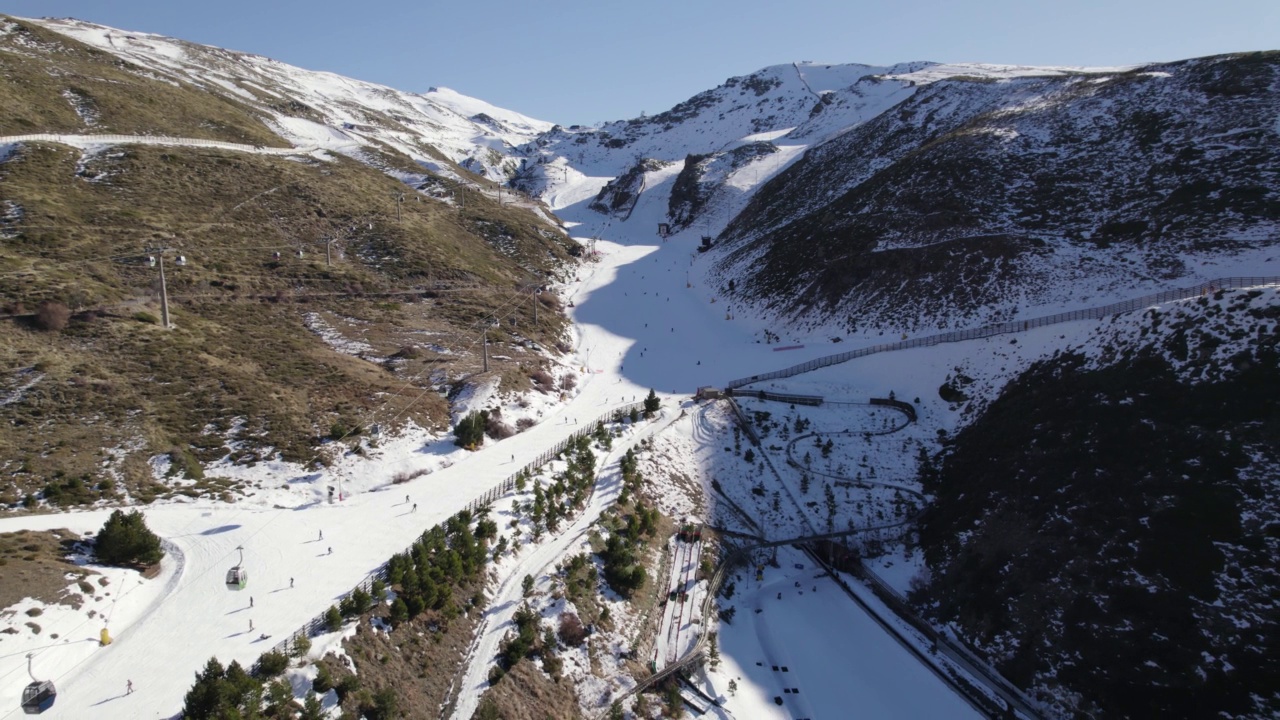 无人机在西班牙内华达山脉的滑雪坡道和索道上空飞行。空中反视频素材