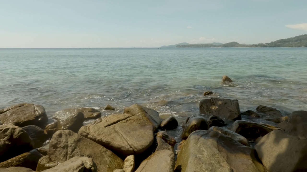 海浪拍打着岩石，青山绿水，蓝天白云。视频素材