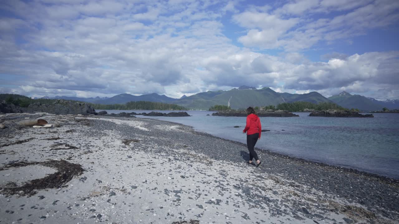 一个女人从海滩上捡贝壳的旅行照片视频素材