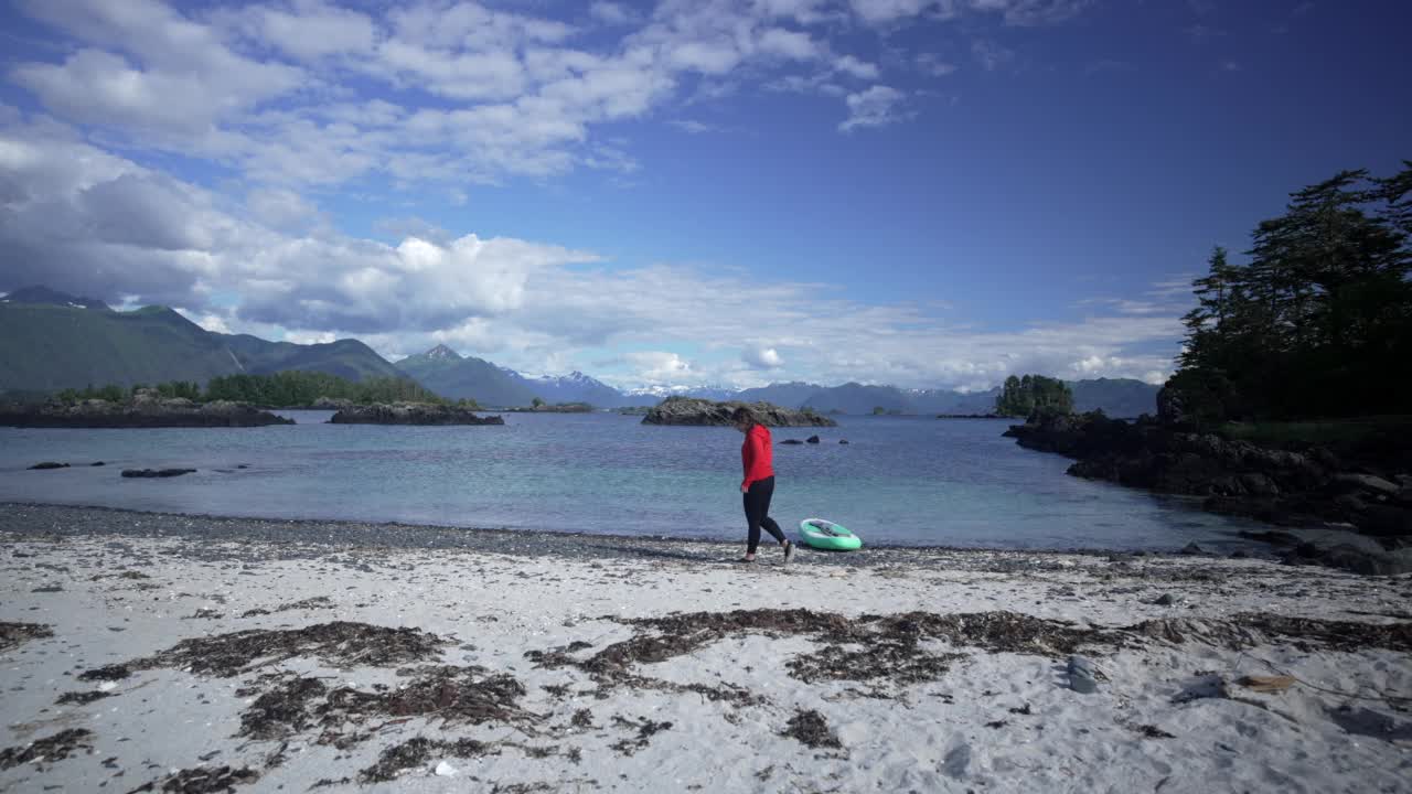 一个女人从海滩上捡贝壳的旅行照片视频素材