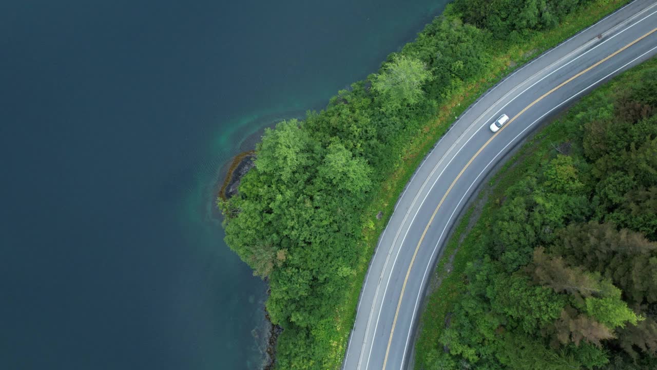 无人机拍摄的一辆汽车在湖边的道路上行驶视频素材