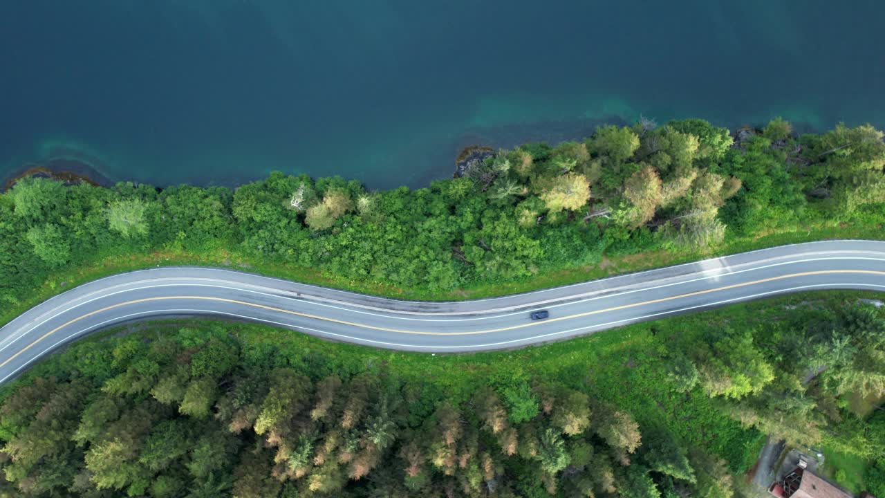 无人机拍摄的一辆汽车在湖边的道路上行驶视频素材