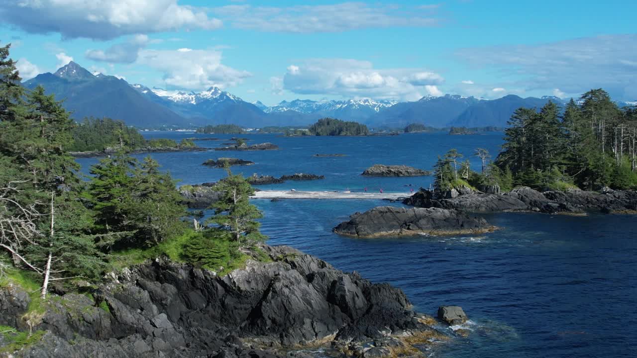 无人机拍摄的人们站在海湾岛屿附近的大陆桥上视频素材