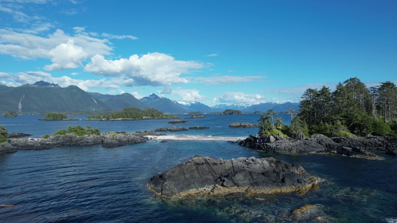 无人机拍摄的人们站在海湾岛屿附近的大陆桥上视频素材