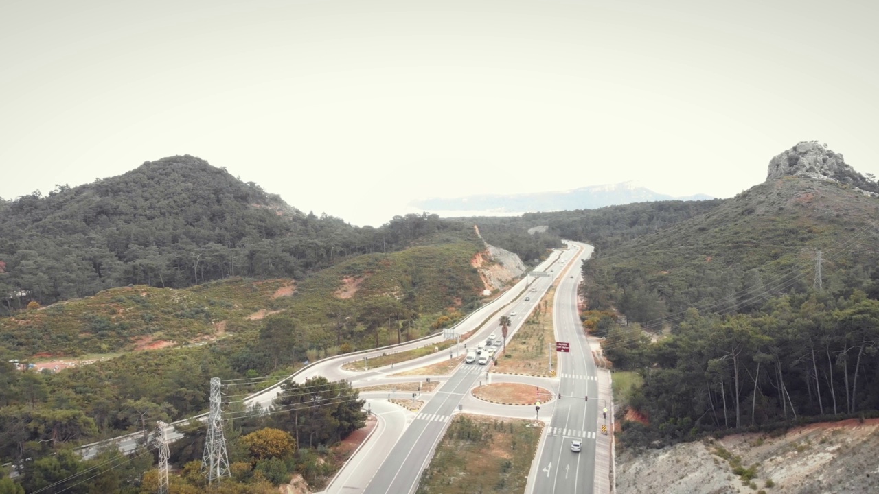 汽车白天在高速公路上行驶。多车道高速公路与沥青灰色的道路。运输的概念。高速公路被群山环绕视频素材