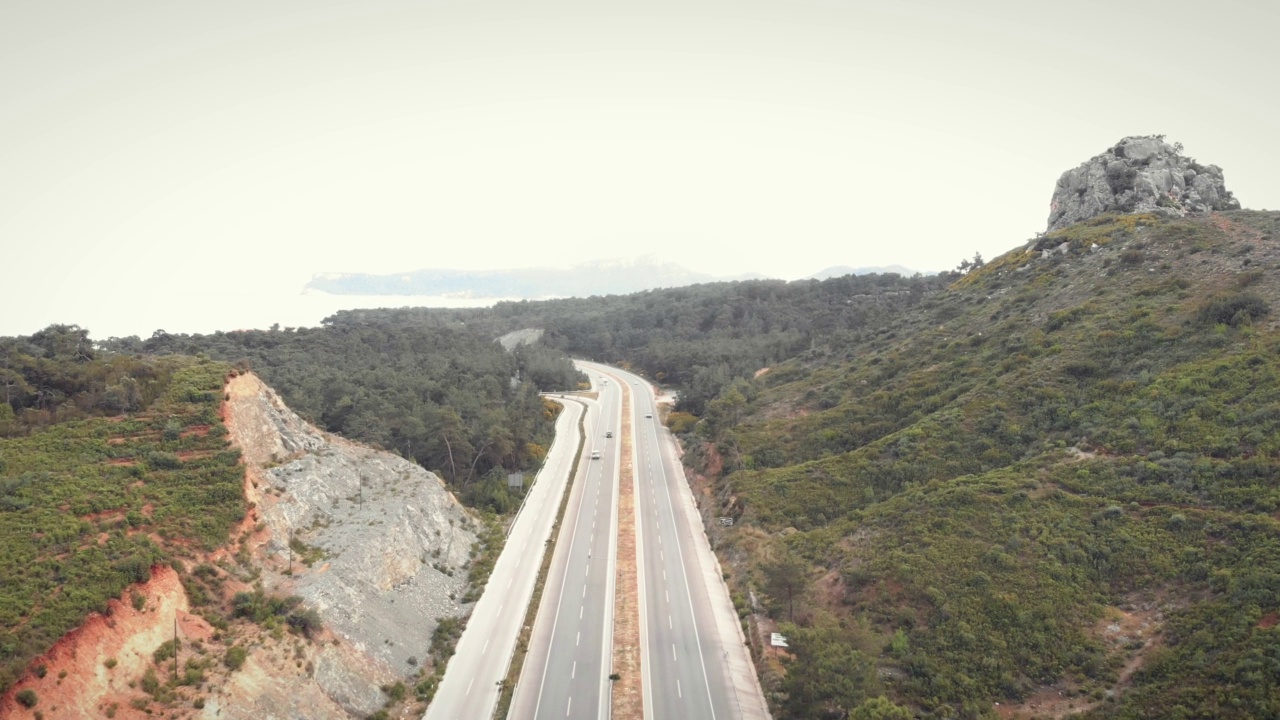 高速公路速度。行驶在高速公路上，有多条道路穿过山区。山区高速公路。汽车和卡车在现代高速公路上快速行驶。运输的概念视频素材