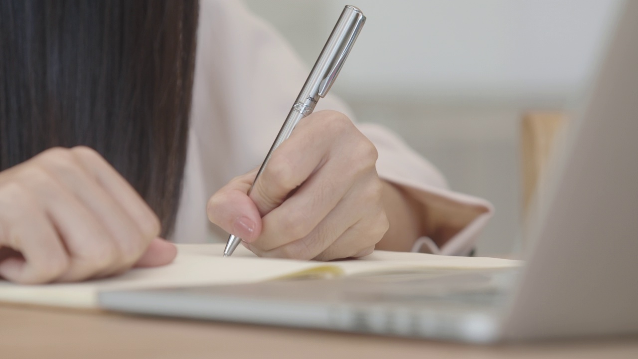 女人的双手用着绿叶前景的笔记本电脑视频素材